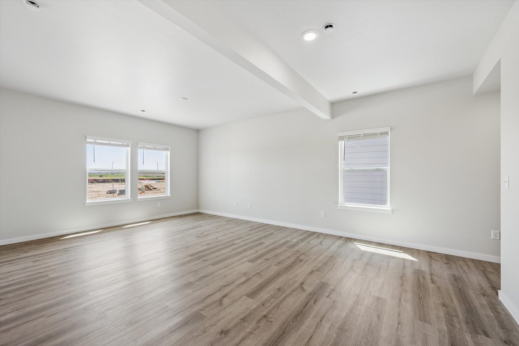 A room with a wood floor and windows.