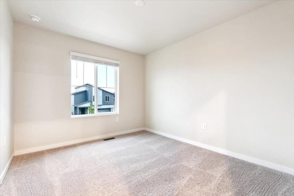 A room with a window and carpet.
