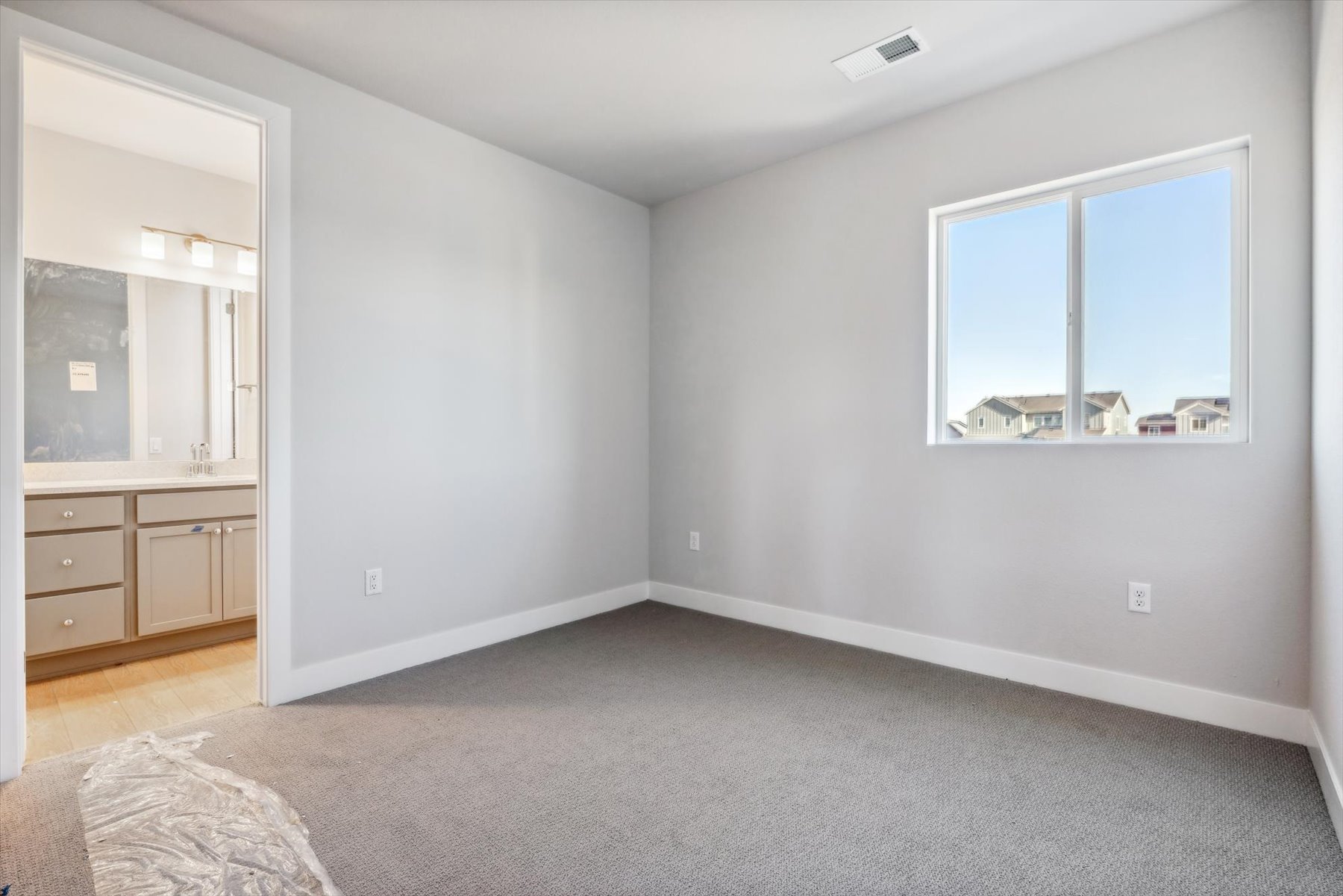 A room with a window and a bed.