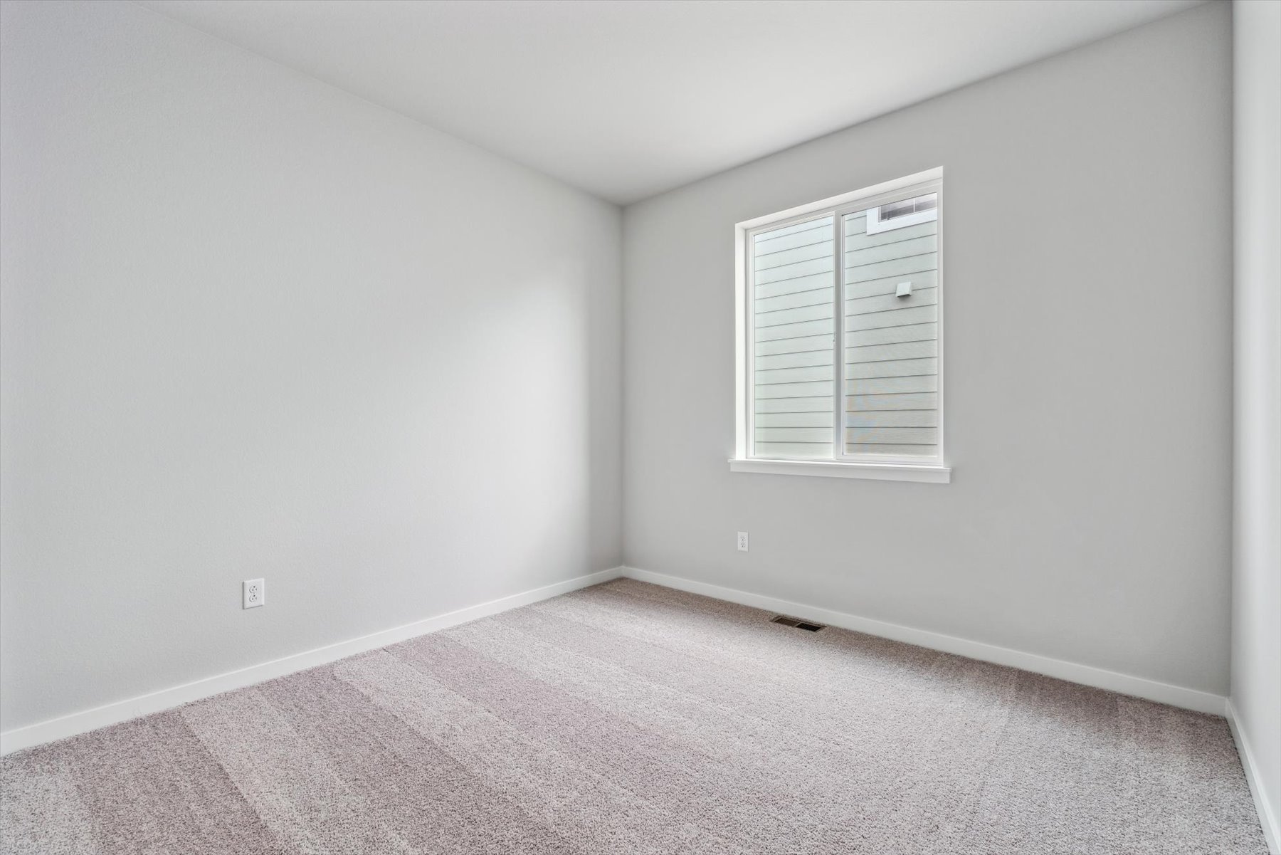A room with a window and a carpet.
