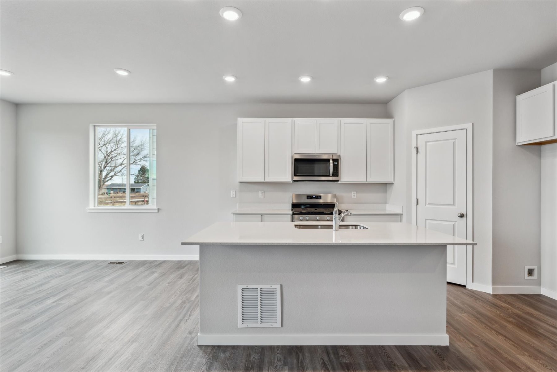 A kitchen with white cabinets.