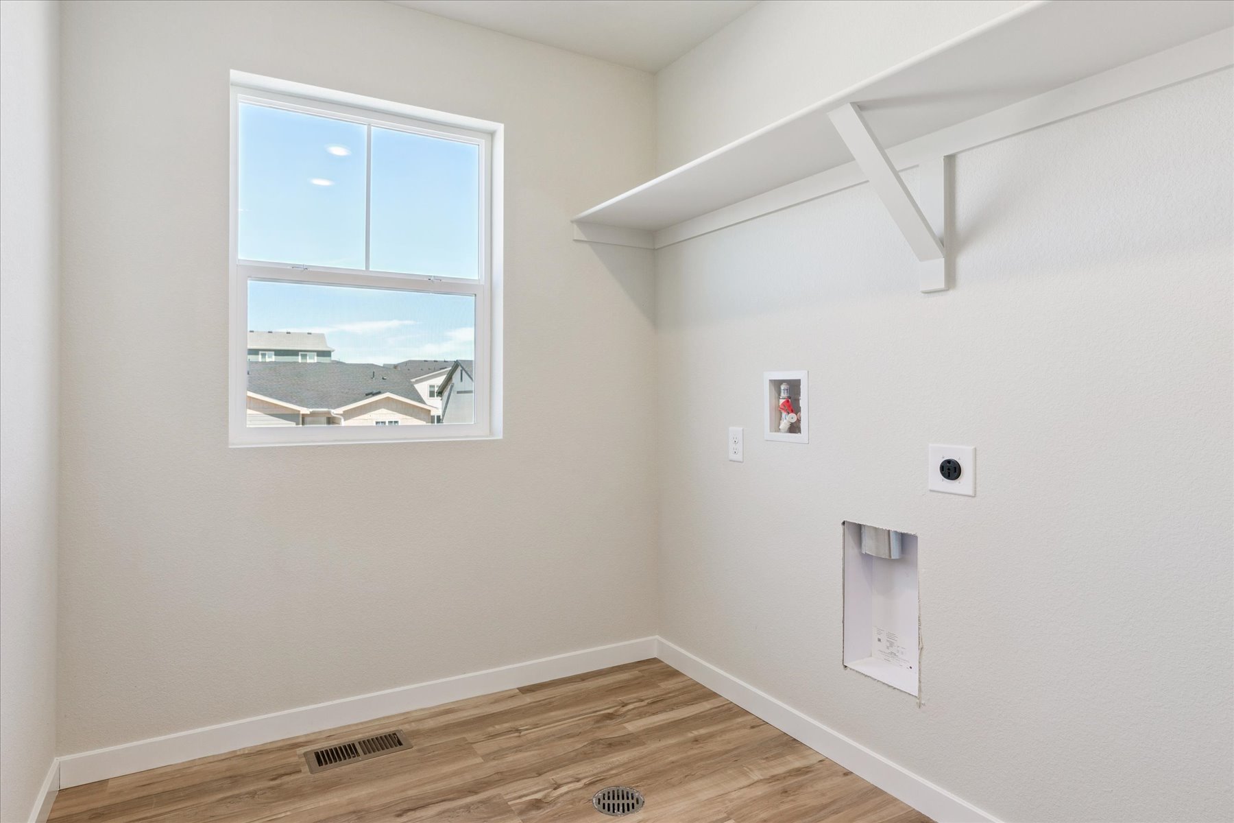 A room with a window and a wood floor.