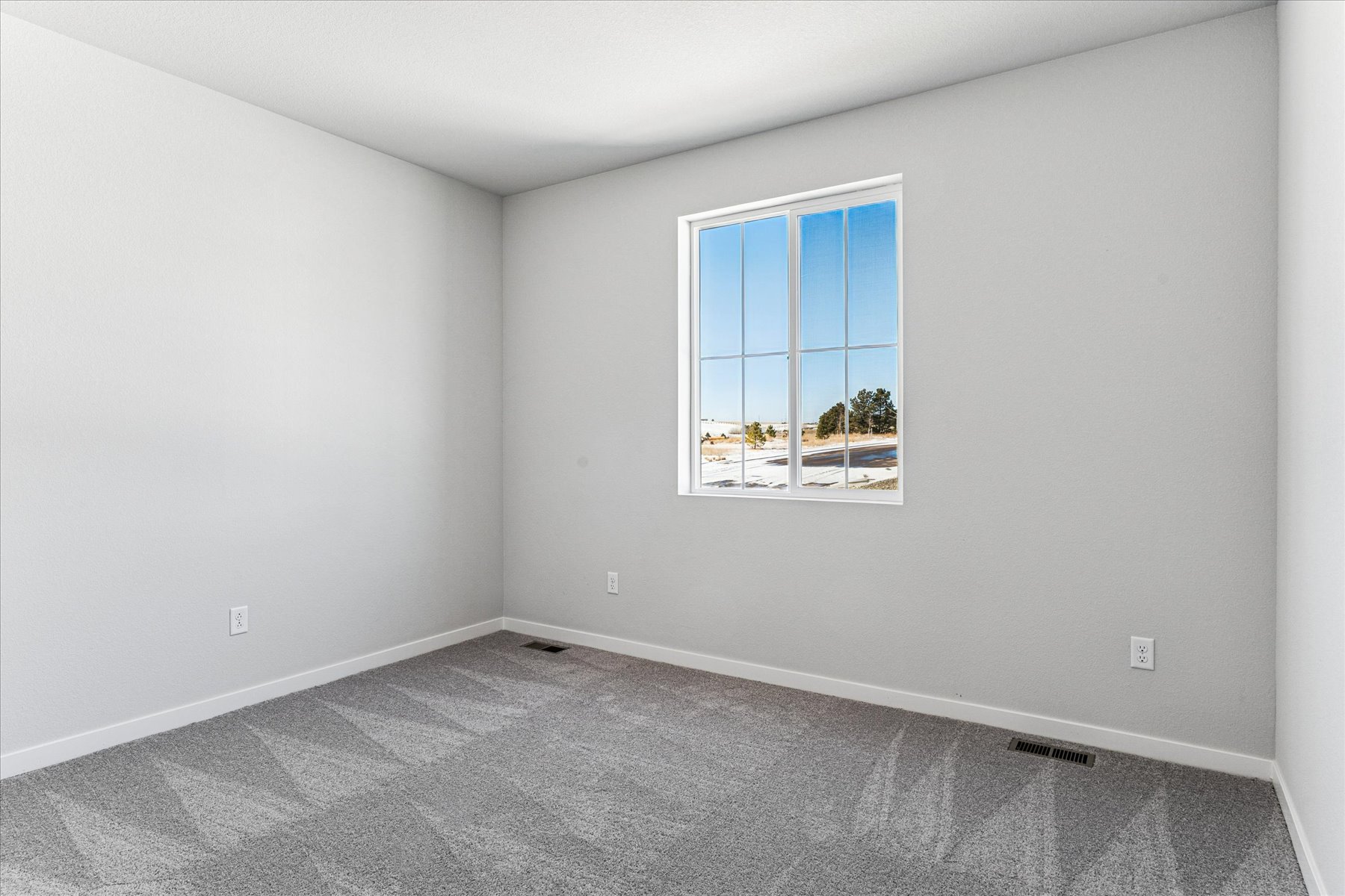 A room with a window and a carpet.