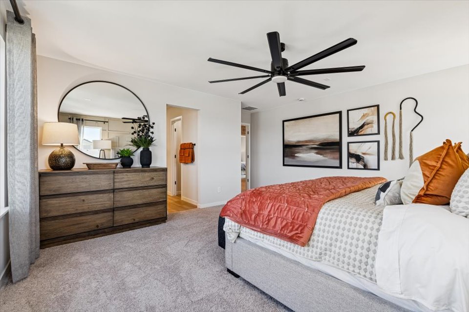 A bedroom with a bed and a fan.