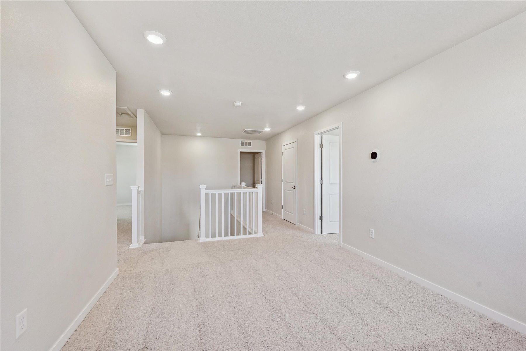 A long hallway with white doors.