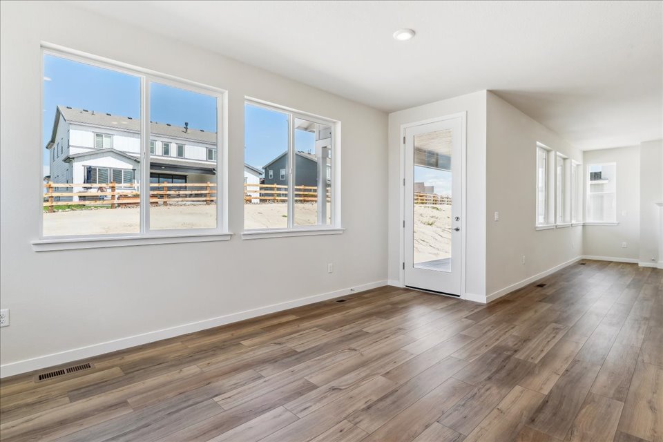A room with a wood floor and windows.