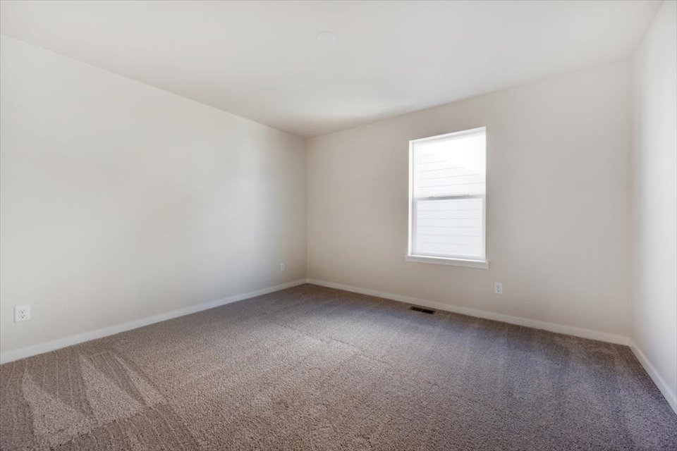A room with a carpet and a window.