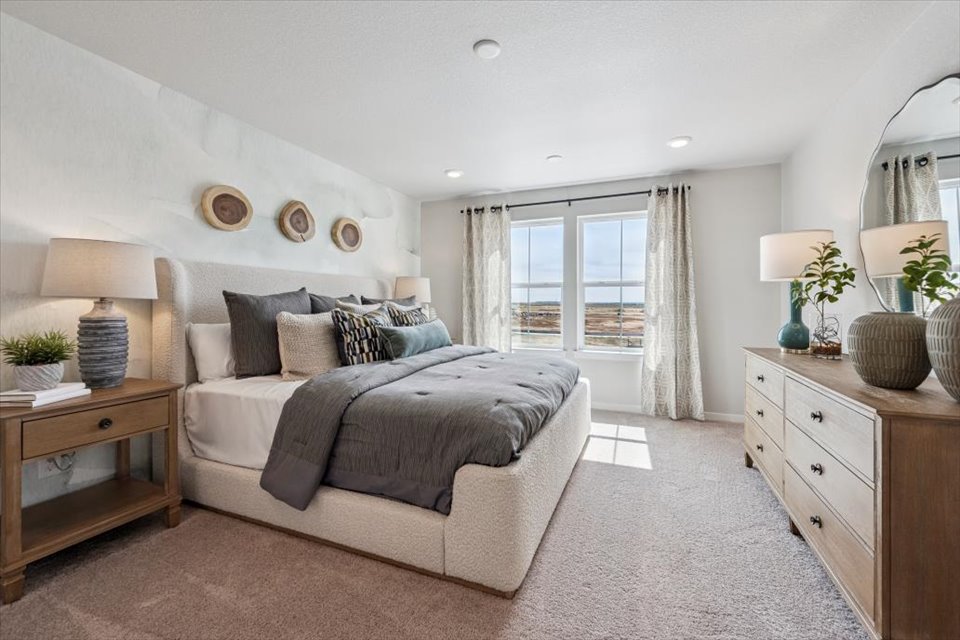 A bedroom with a bed and a mirror.