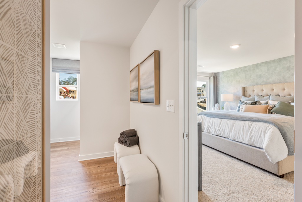 A bedroom with a bed and a chair.