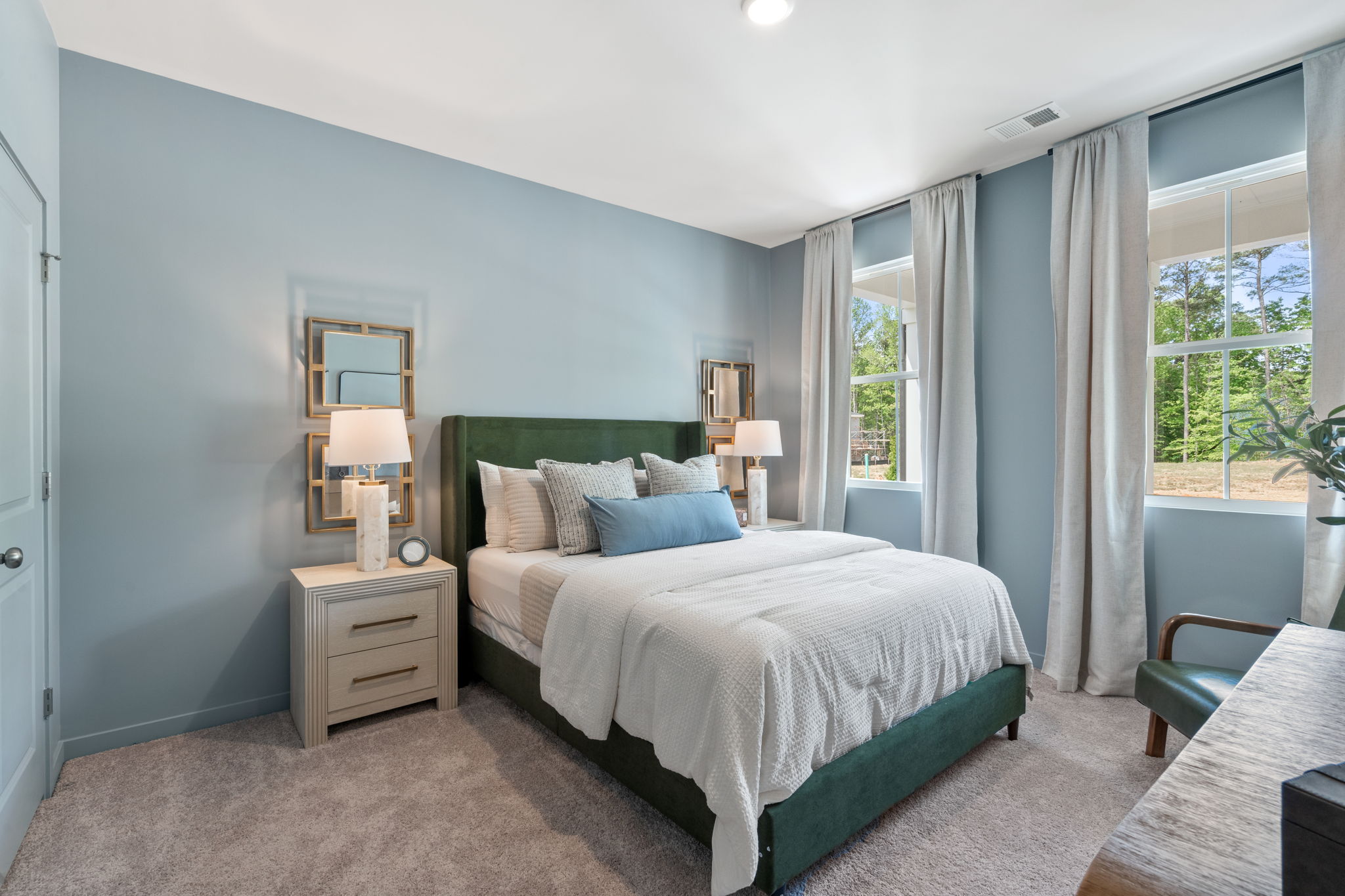 A bedroom with a bed and a chair.