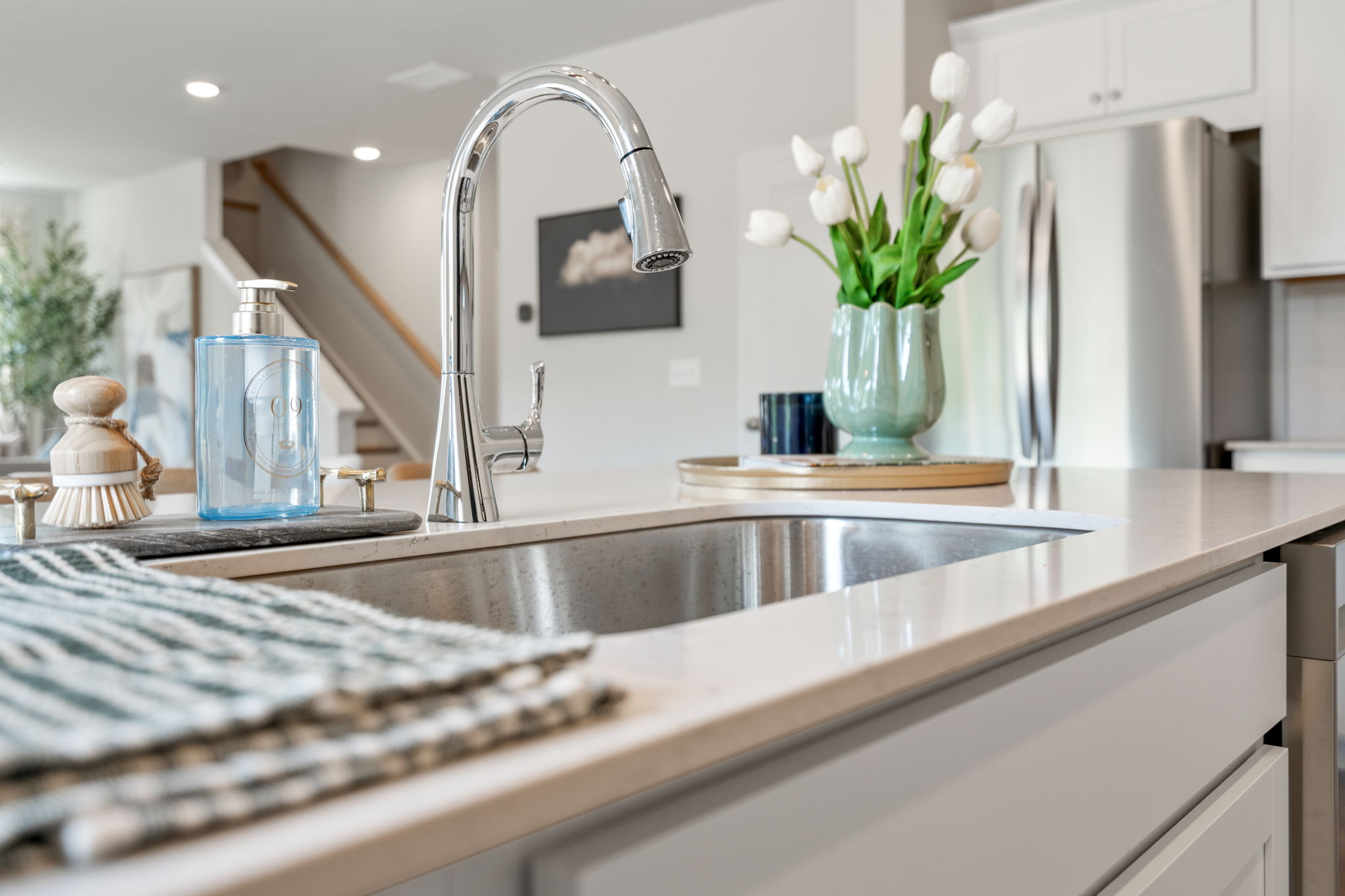 A kitchen with a sink and a vase with flowers.