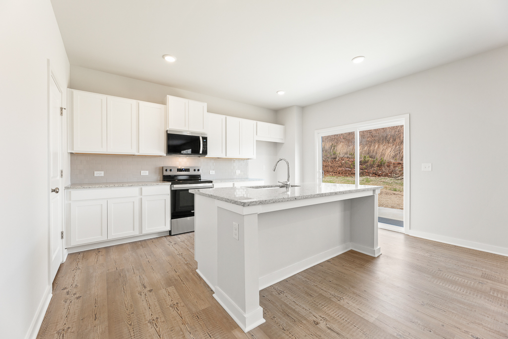 A kitchen with white cabinets.