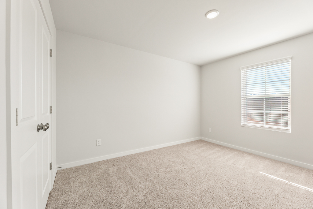 A room with a carpet and a window.