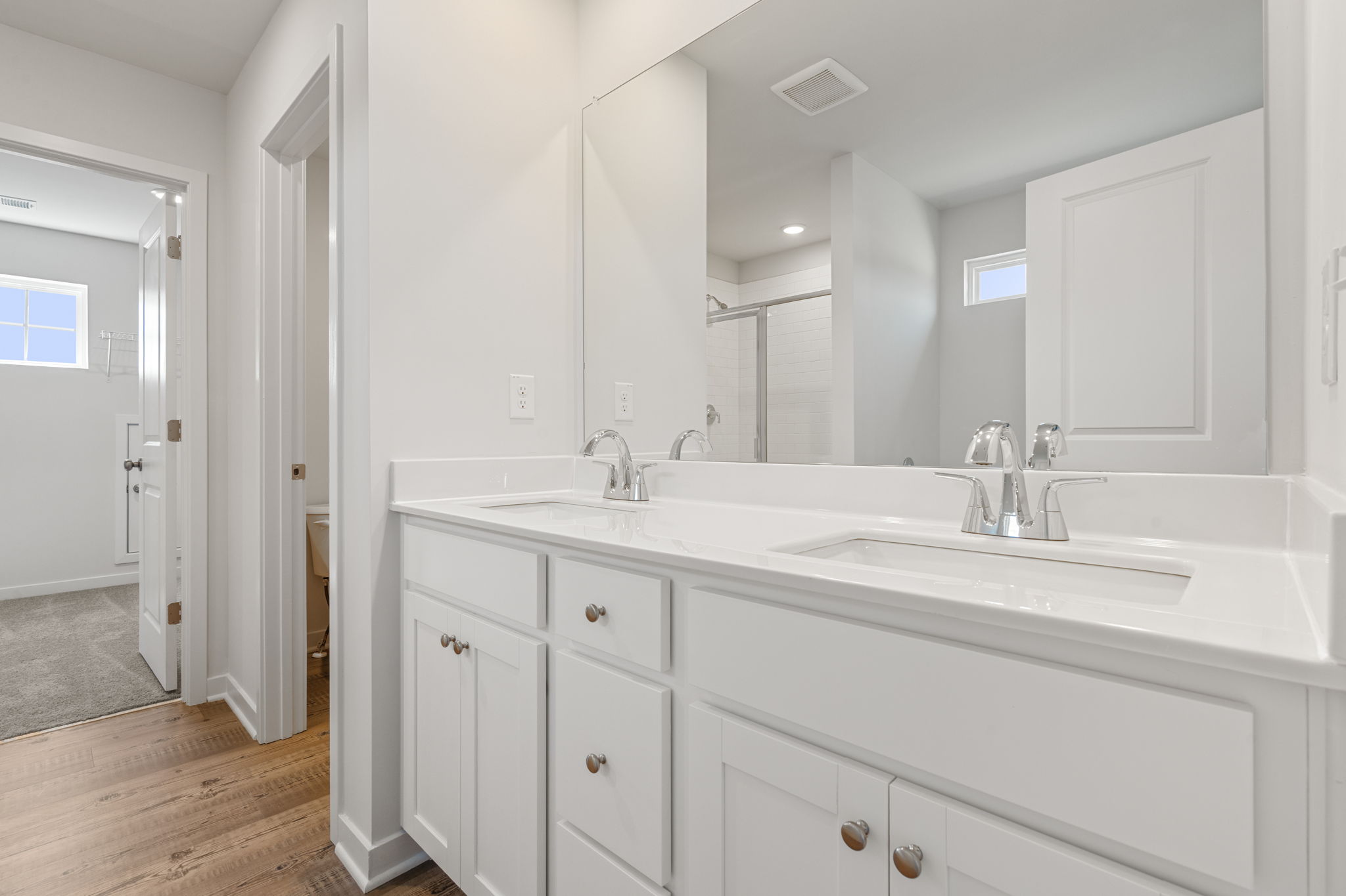 A bathroom with white cabinets.