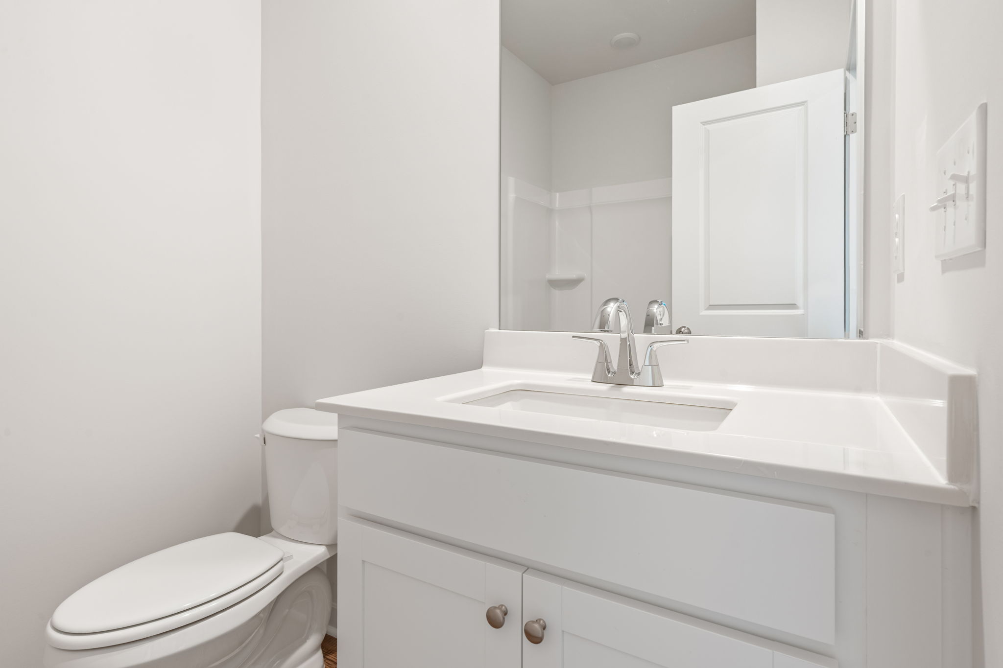 A bathroom with a sink toilet and mirror.