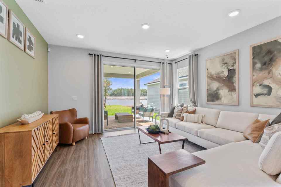 Silverbell II Model Home Living Room with Large Couch and Patio Doors at Camden Woods in Kingsland, GA
