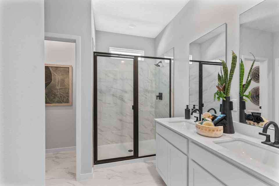 Silverbell II Model Home Primary Bath with Dual Vanity Sinks and Glass Shower at Camden Woods in Kingsland, GA
