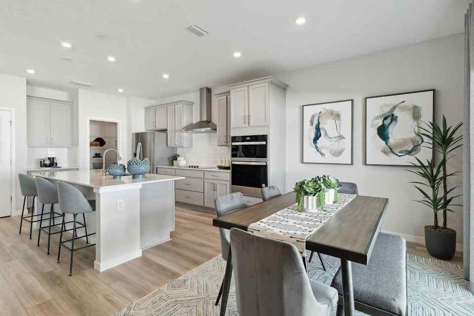 A kitchen with a dining table and chairs.