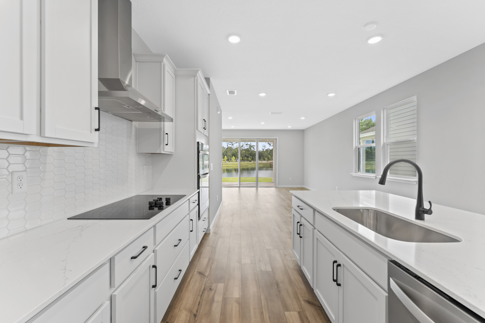 Miramar Floorplan Lot 81 Kitchen with White Cabinets and Black Hardware at Concourse Crossing in Fernandina Beach