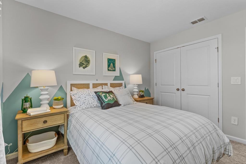 A bedroom with a bed and lamps.