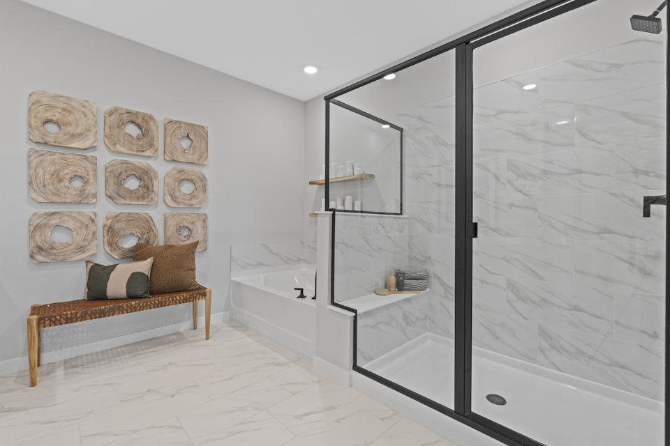 Kenai Model Home Primary Bathroom with Freestanding Tub and Glass Shower at Reserve East in Flagler Beach