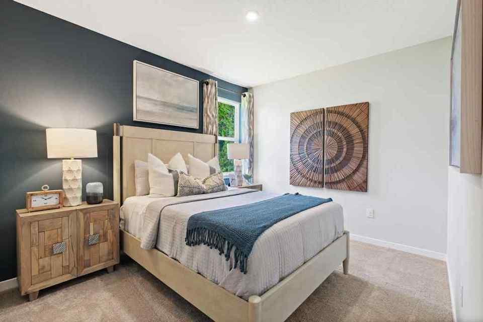 A bedroom with a bed and lamps.