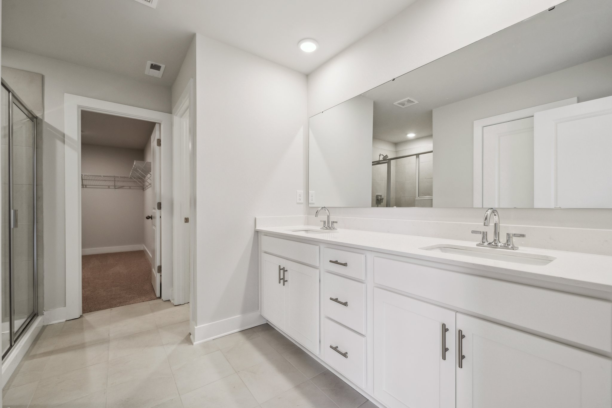 A bathroom with white cabinets.