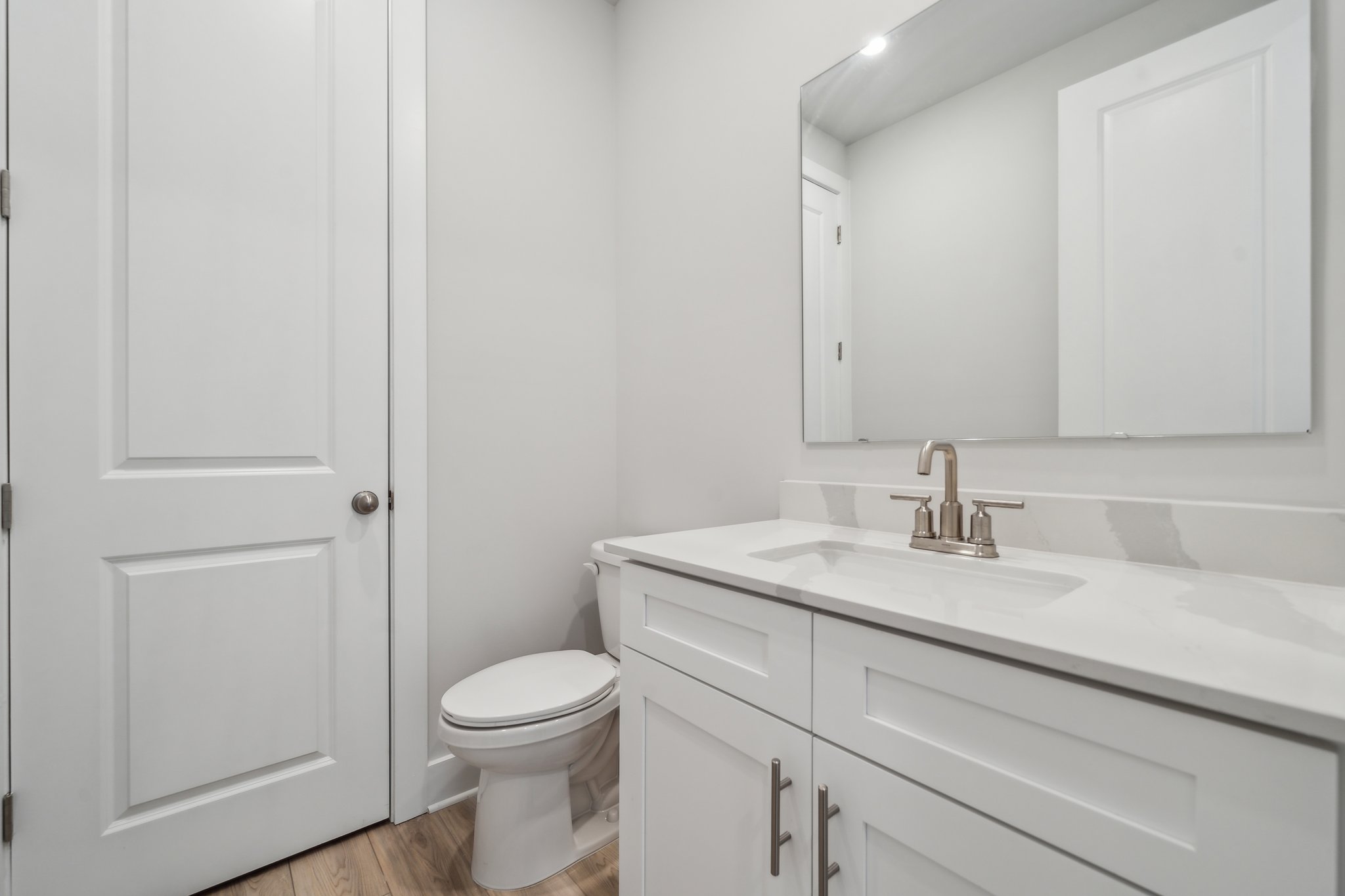 A bathroom with white cabinets.