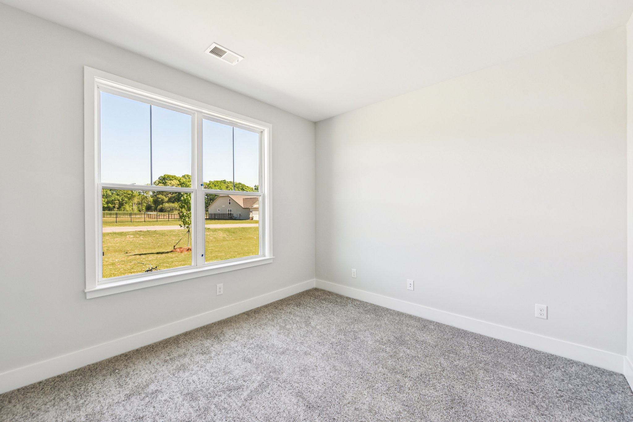 A room with a window and a carpet.