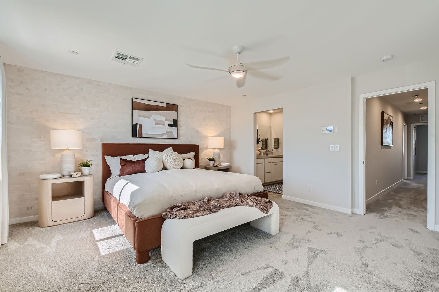 A bedroom with a bed and lamps.