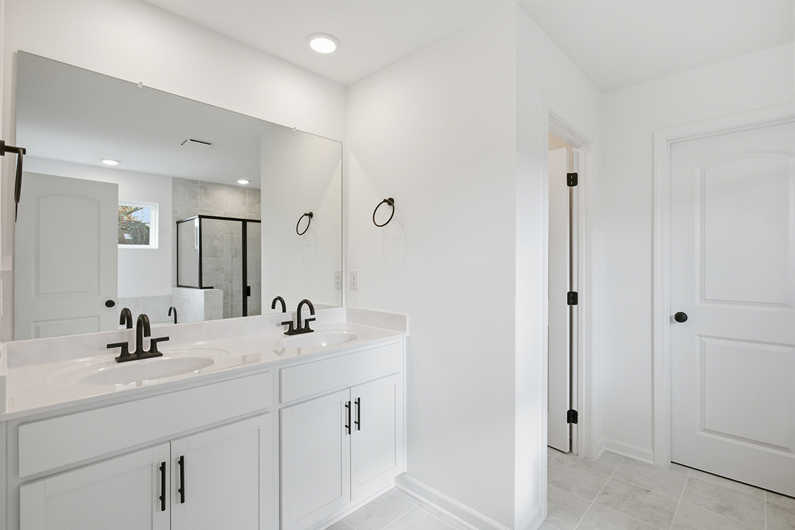 A bathroom with white cabinets.