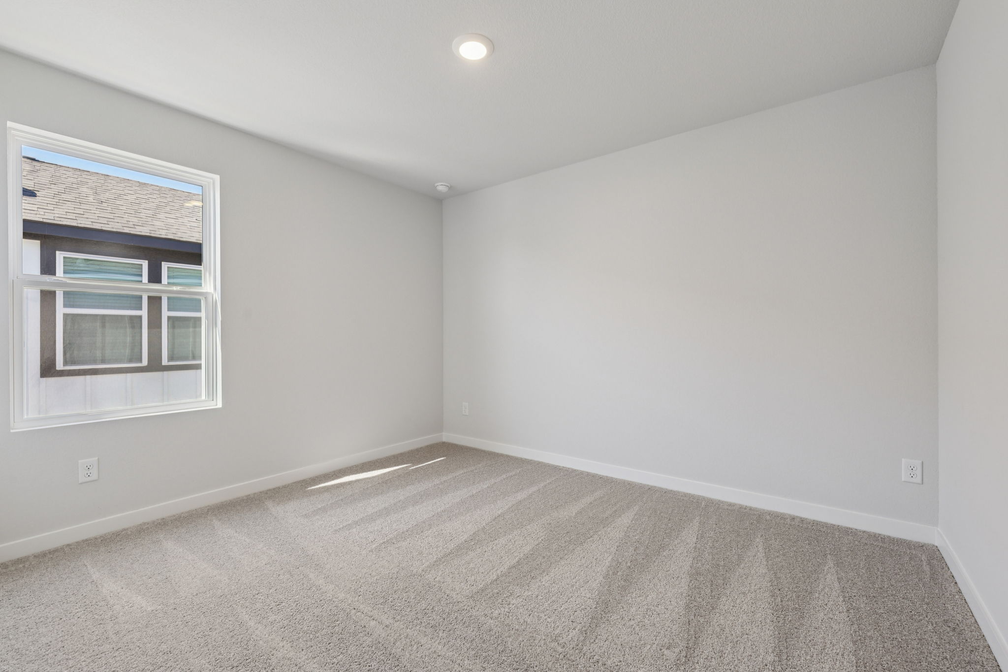 A room with a window and a carpet.