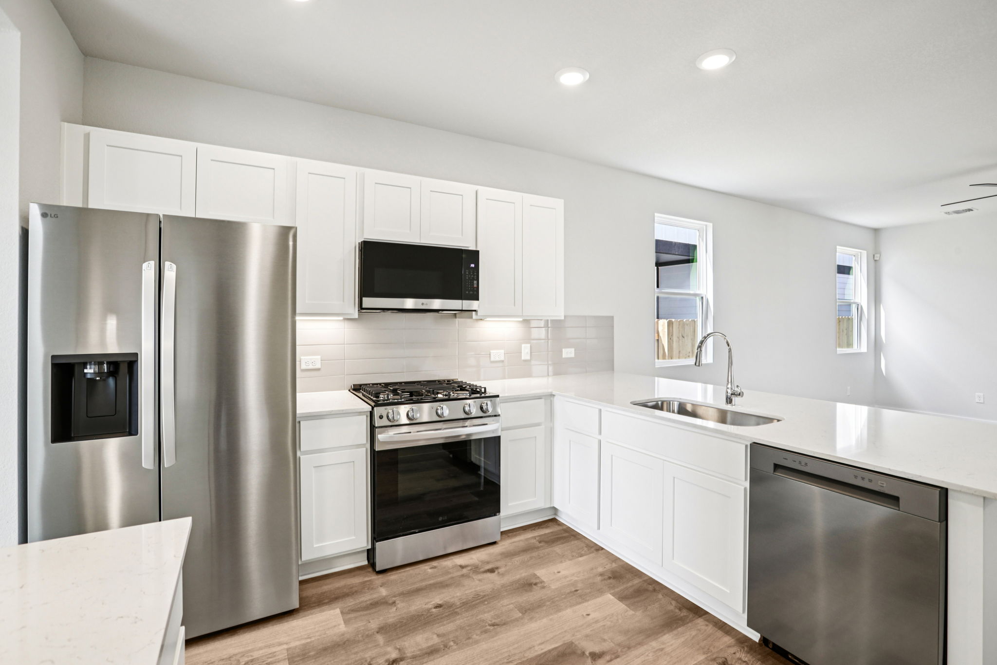 A kitchen with white cabinets.