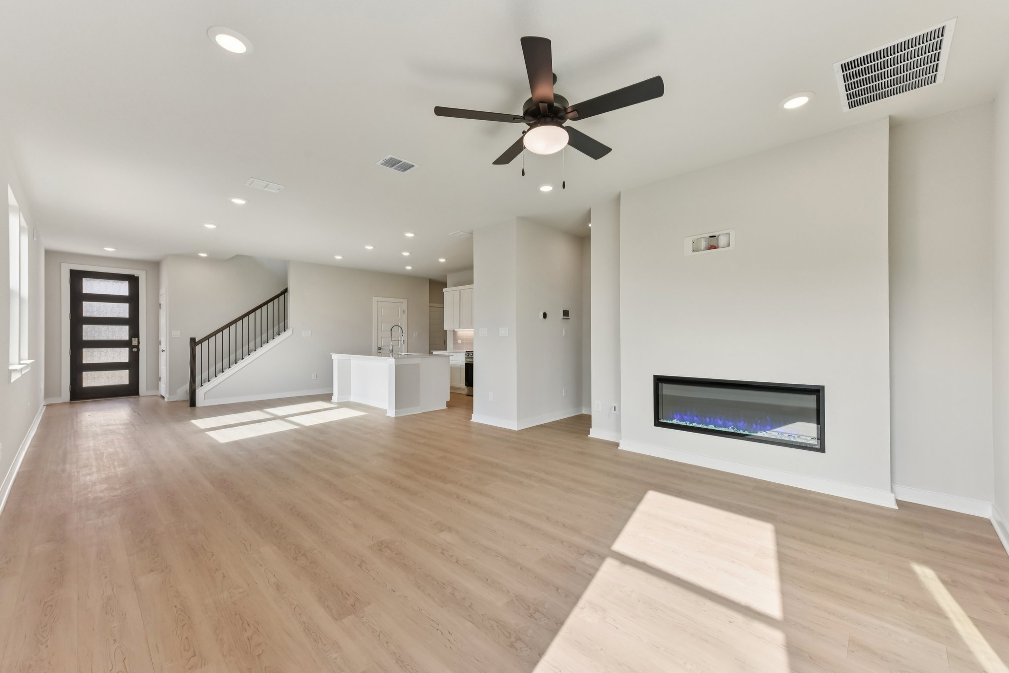A room with a wood floor and a wood floor with a ceiling fan.