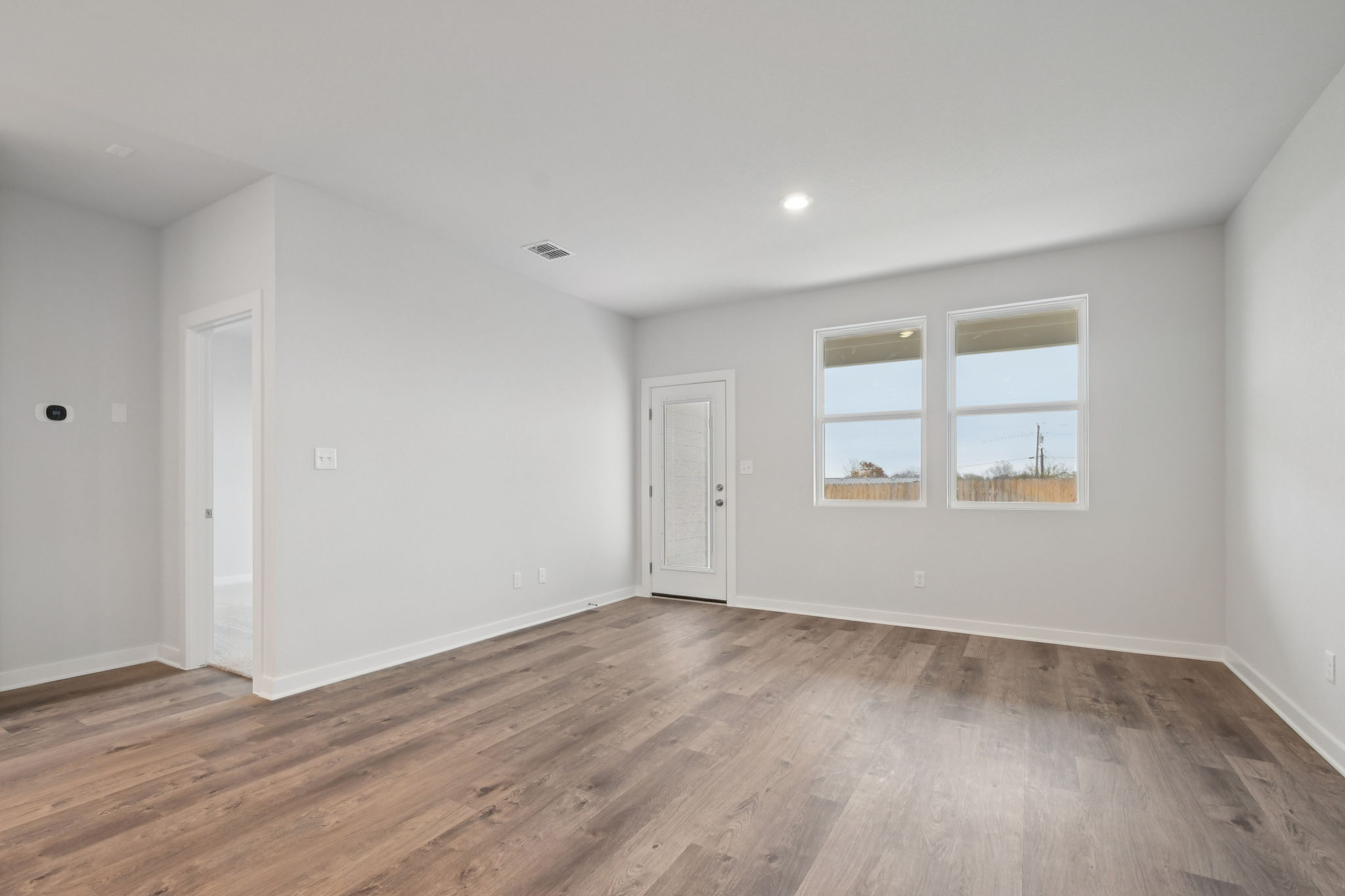 A room with a wood floor and white walls.