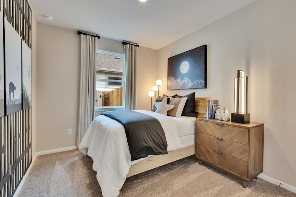 A bedroom with a bed and a dresser.