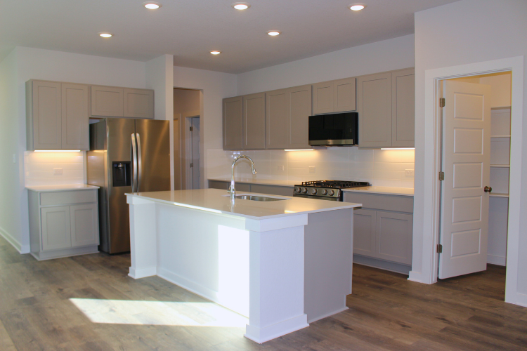 A kitchen with white cabinets.