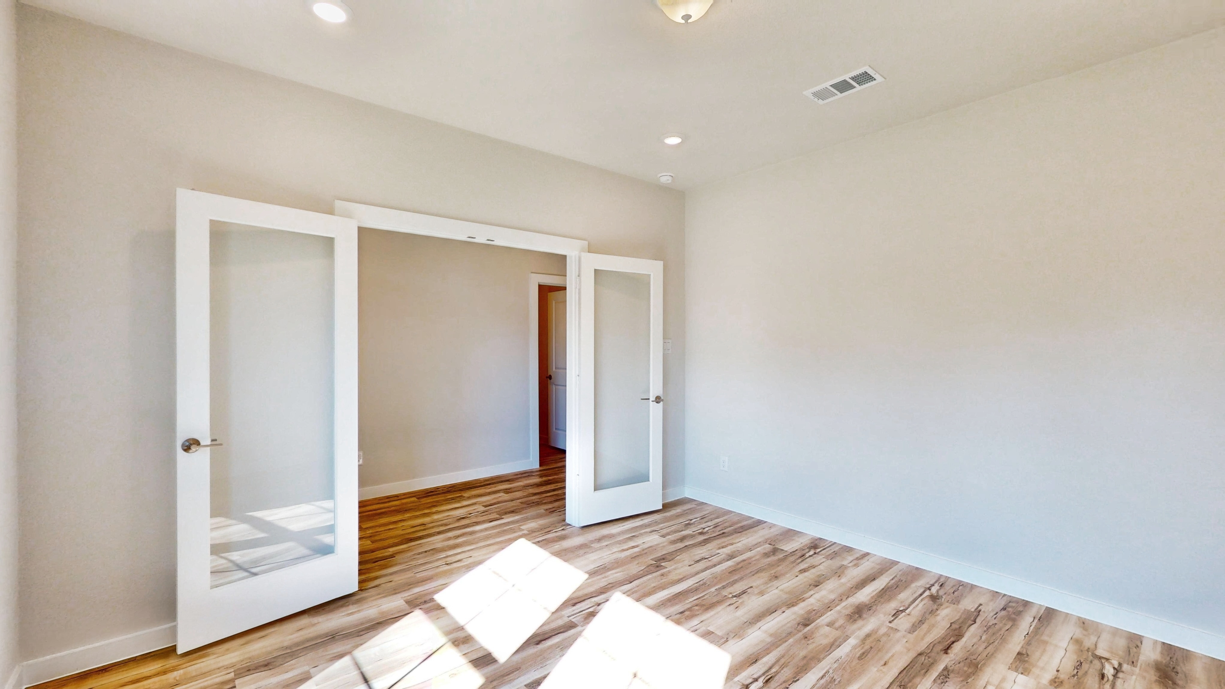 A room with a wood floor and a glass door.