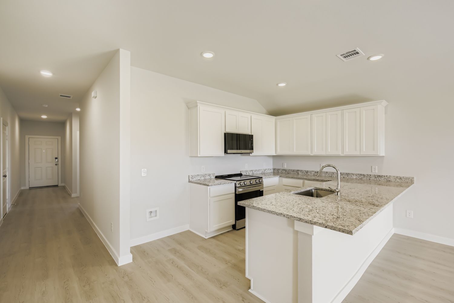 A kitchen with white cabinets.