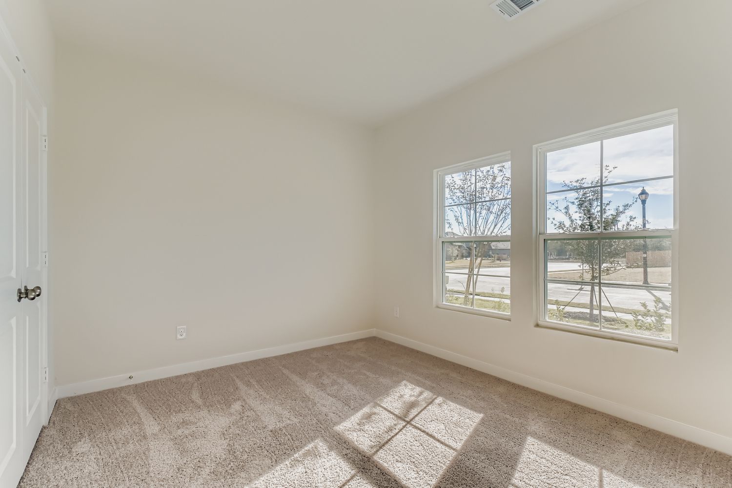 A room with windows and a rug.