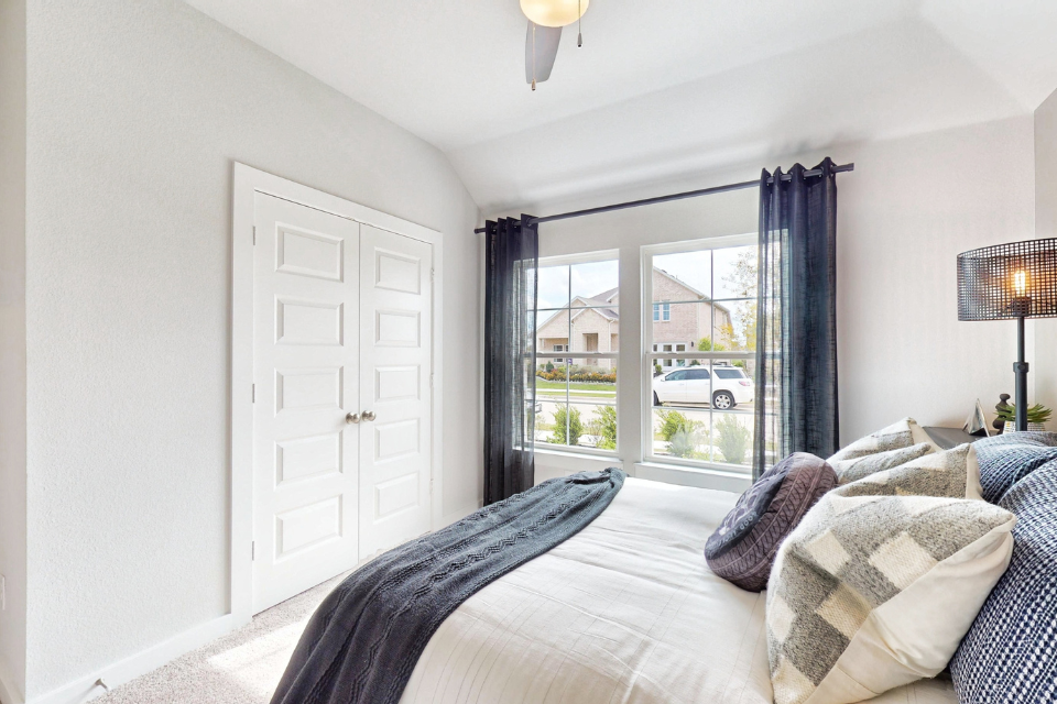 A bedroom with a large window.