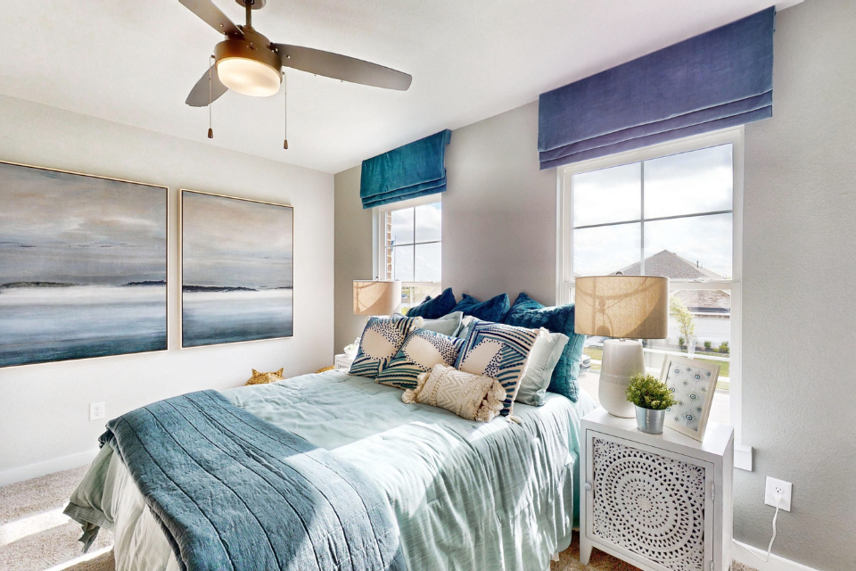 A bedroom with a bed and a fan.