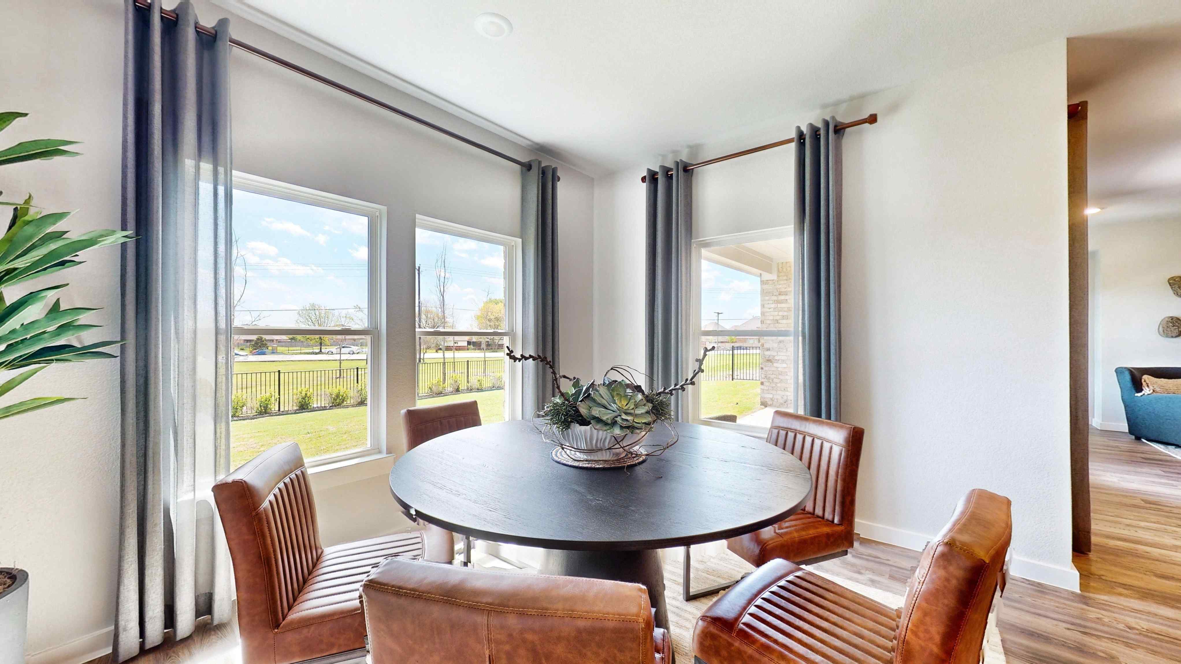 A dining room table with chairs and a large window.