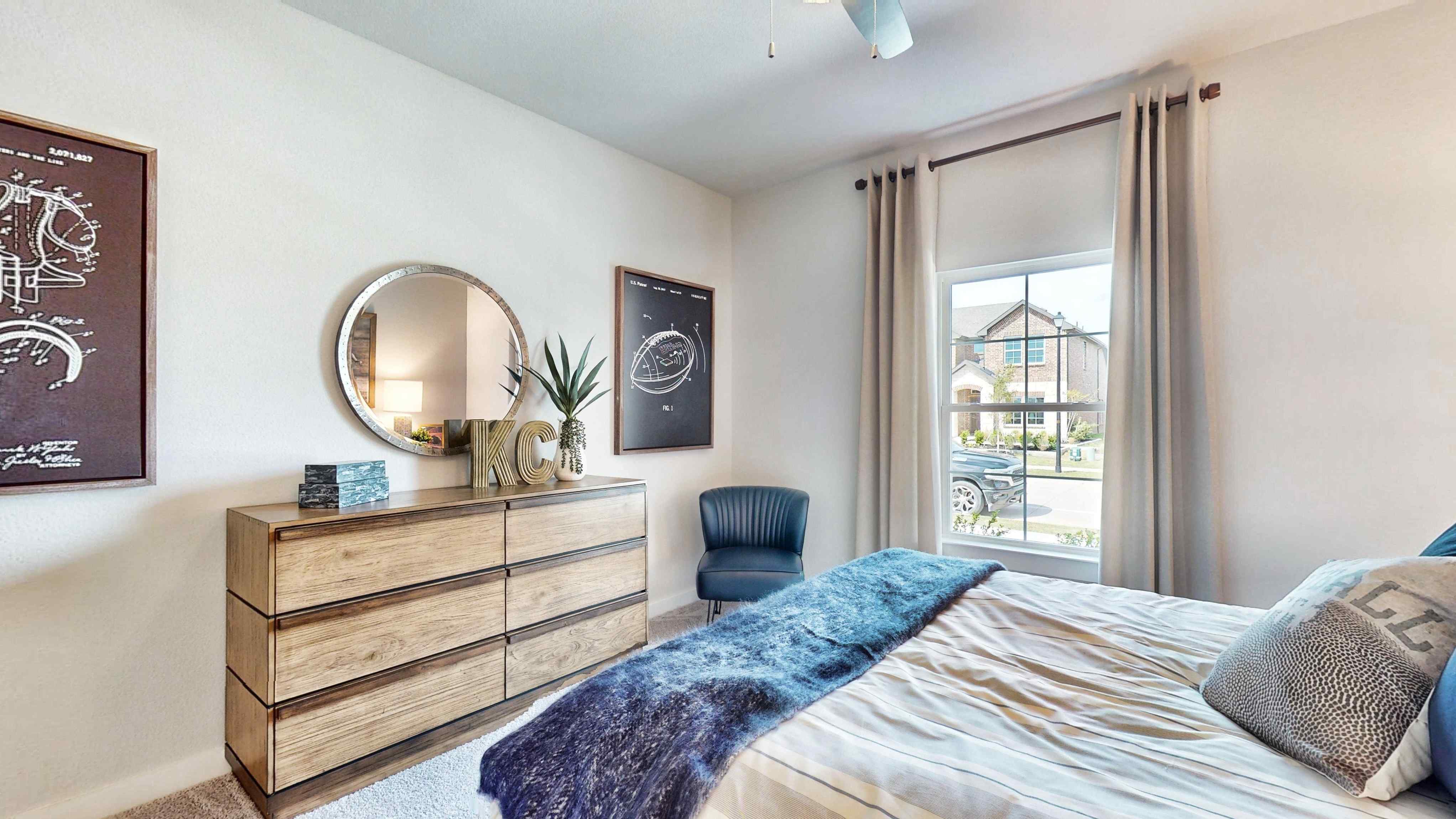 A bedroom with a bed and a chair.