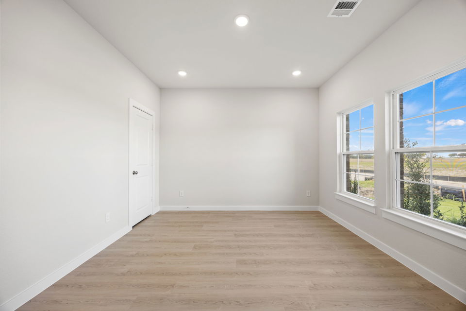 A room with windows and a wood floor.