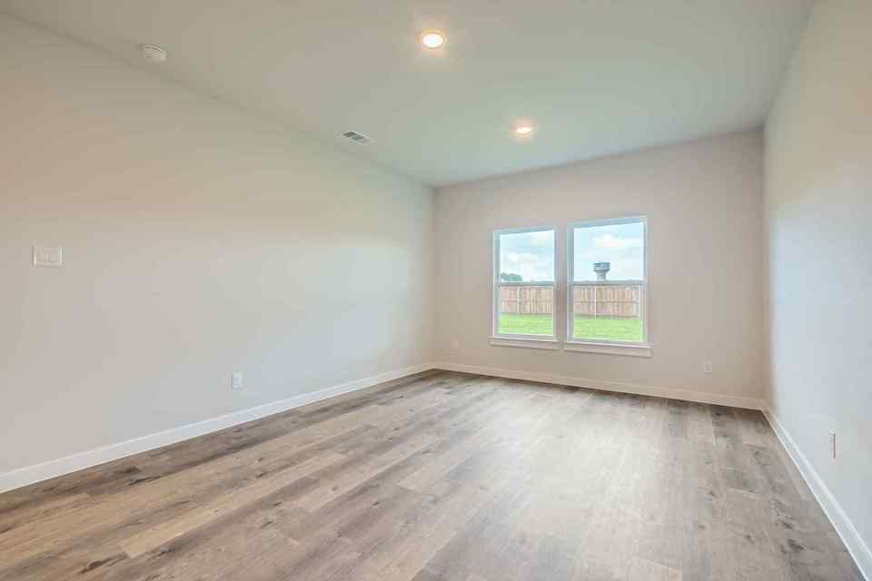 A room with a wood floor and a window.
