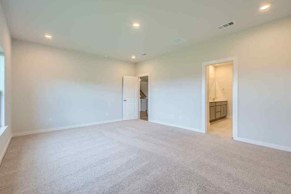 A room with a carpet and a door.