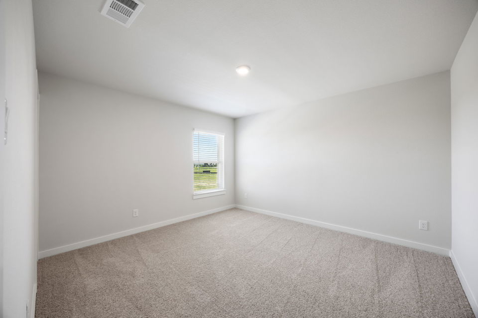 A room with a carpet and a window.