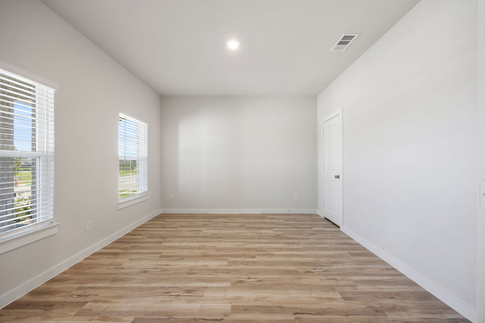 A room with a wood floor and windows.