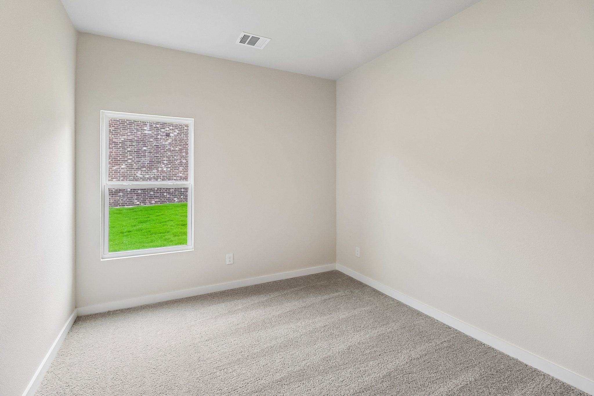 A room with a window and a carpet.